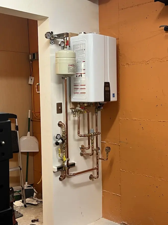 Plumbing technician inspecting water heater connections in Cuero